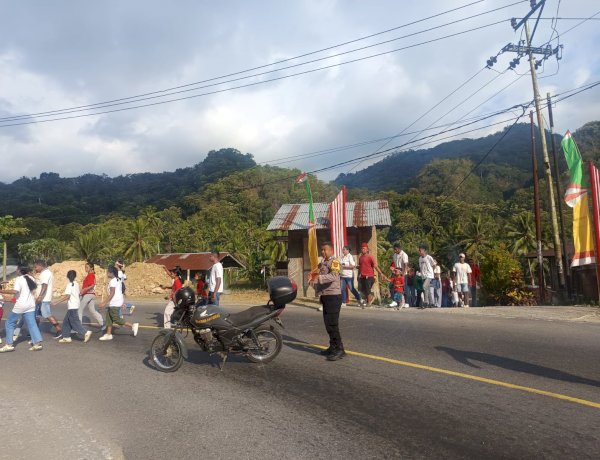 Hadir di Tengah Warga, Bhabinkamtibmas Desa Roa Polsek Detusoko Kawal Kemeriahan Kirab Rakyat Desa Wolotolo